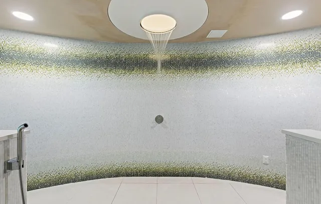 a bathroom with a glass shower door and a mirror