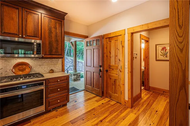 a view of a patio with couches table and chairs under an umbrella