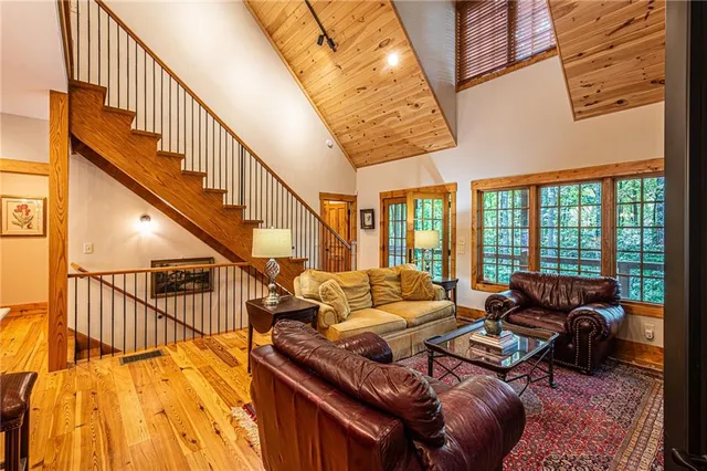 a bedroom with a bed ceiling fan and a wooden floor