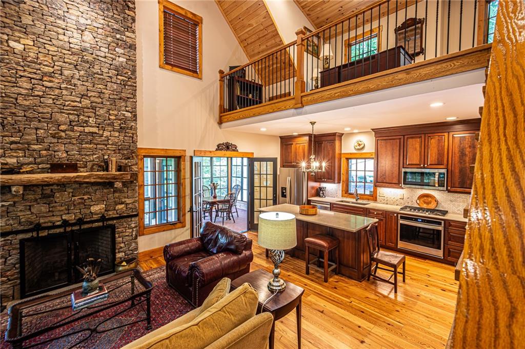 1038 Wilkins Cove Road Suches, GA 30572 - Photo 19 of 89 a view of a patio with couches table and chairs under an umbrella