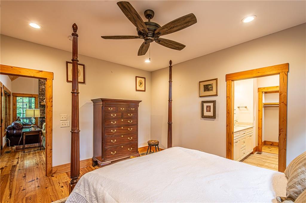 1038 Wilkins Cove Road Suches, GA 30572 - Photo 25 of 89 a bedroom with a bed ceiling fan and a wooden floor