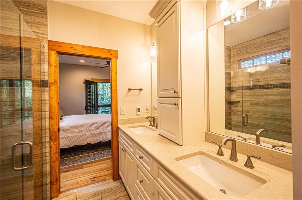 1038 Wilkins Cove Road Suches, GA 30572 - Photo 32 of 89 a en suite bathroom with a double vanity sink and a mirror