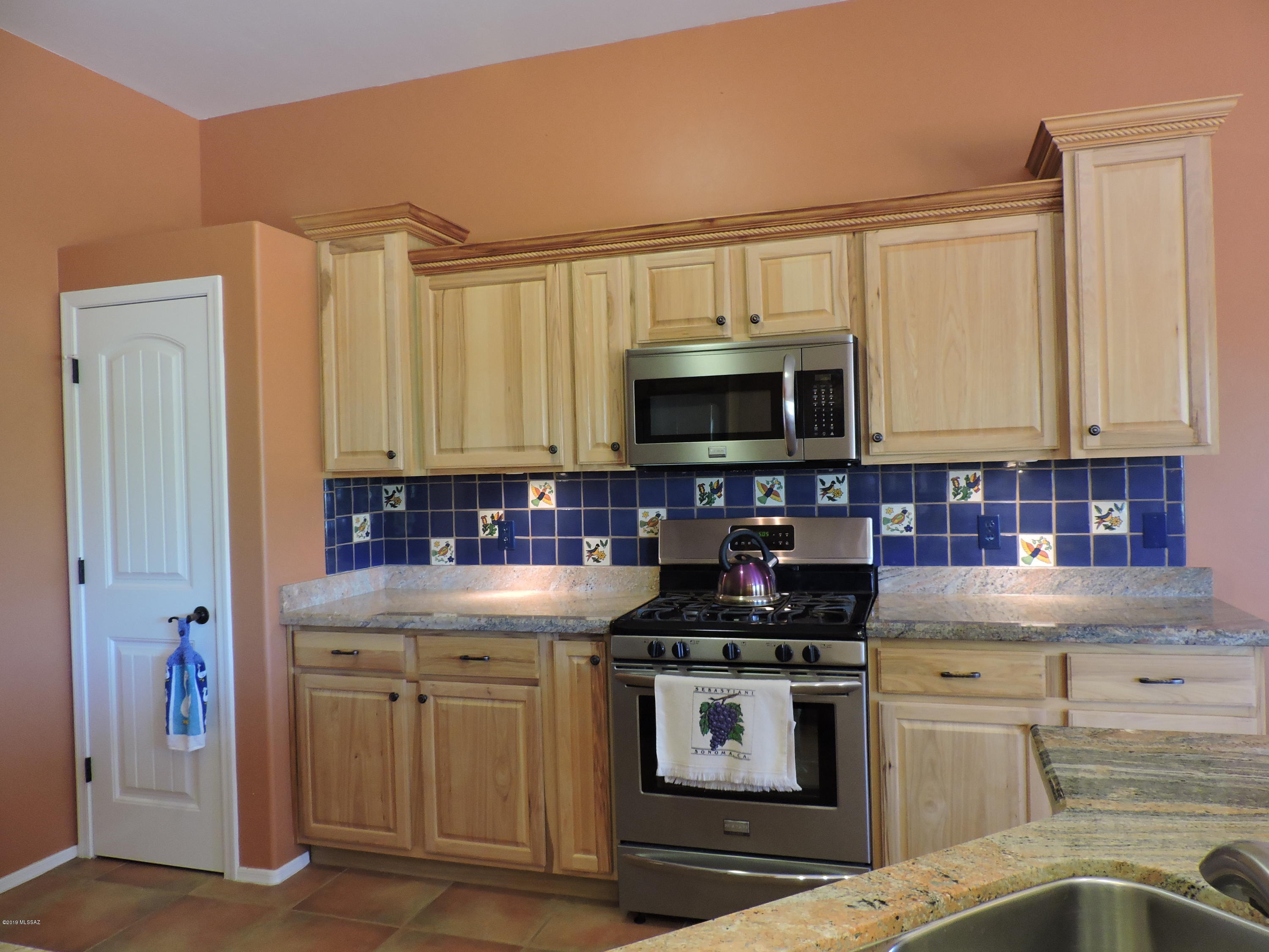 1786 Zimmer Court Rio Rico, AZ 85648 - Photo 28 of 42 a kitchen with stainless steel appliances a stove a sink and a microwave