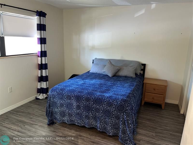 Brandywine Condominiums Gainesville, FL 32608 - Photo 15 of 18 a bed sitting in a bedroom next to a window with wooden floor