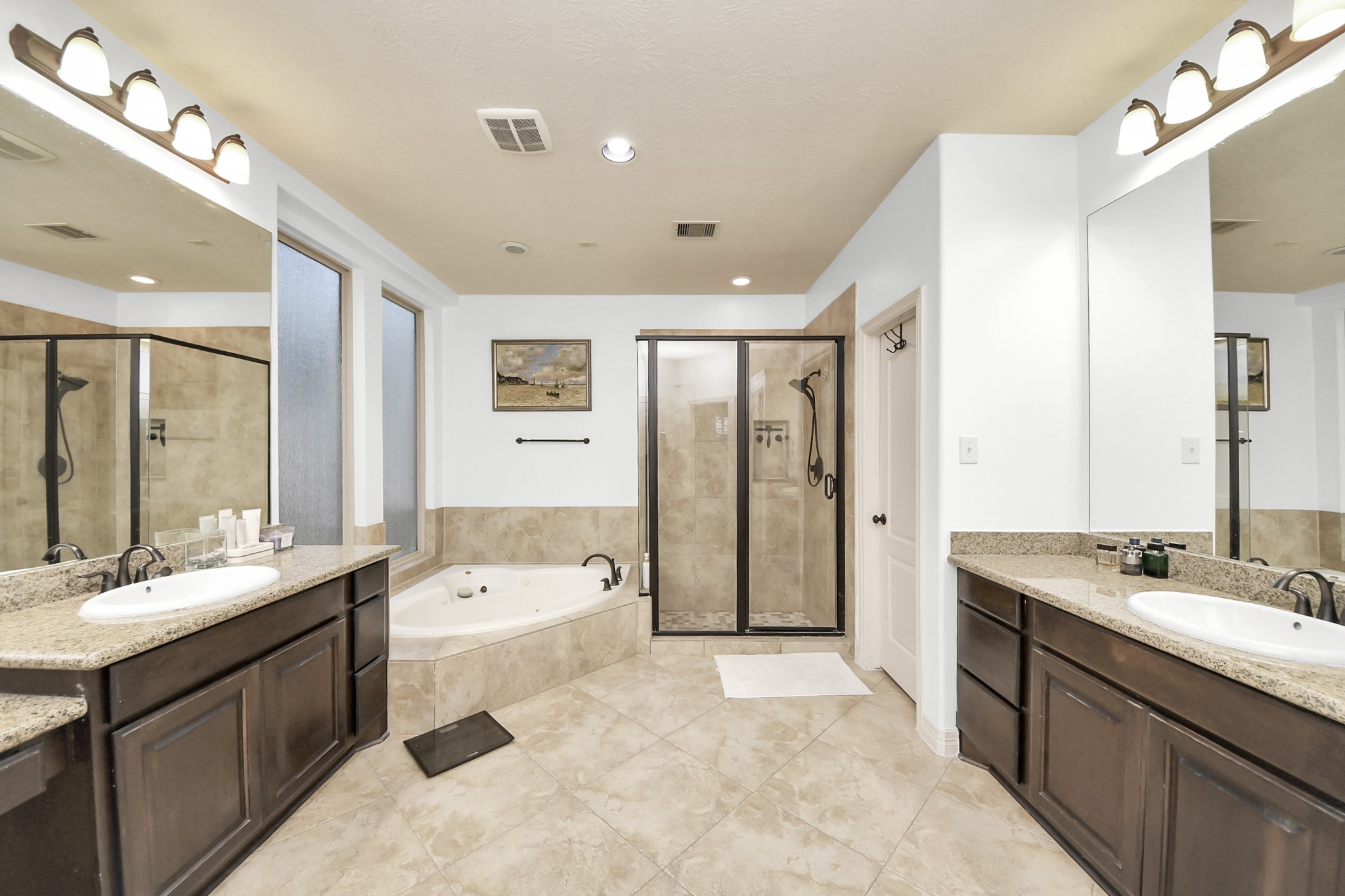 10410 Mossback Pine Road Katy, TX 77494 - Photo 15 of 34 a bathroom with a tub a double vanity sink double vanity and a large mirror