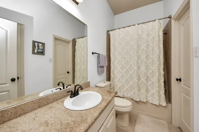 a bathroom with a granite countertop sink toilet and shower