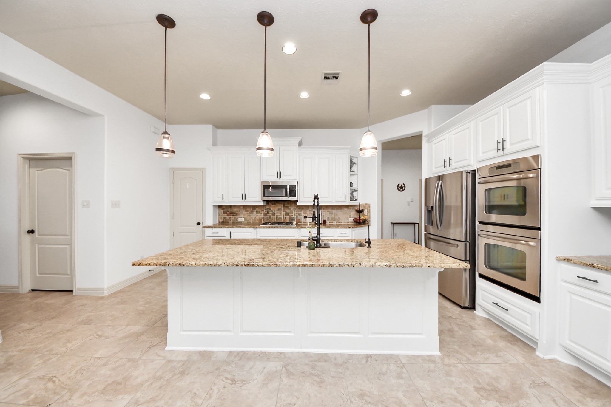 10410 Mossback Pine Road Katy, TX 77494 - Photo 8 of 34 a view of kitchen with kitchen island a counter top stainless steel appliances and cabinets