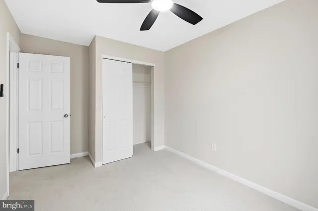 an empty room with a ceiling fan and a window