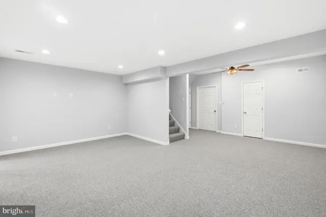 an empty room with a ceiling fan and window