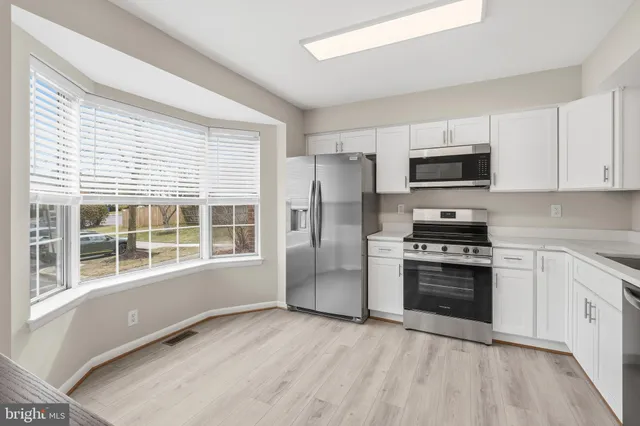 a kitchen with stainless steel appliances a refrigerator and a stove top oven