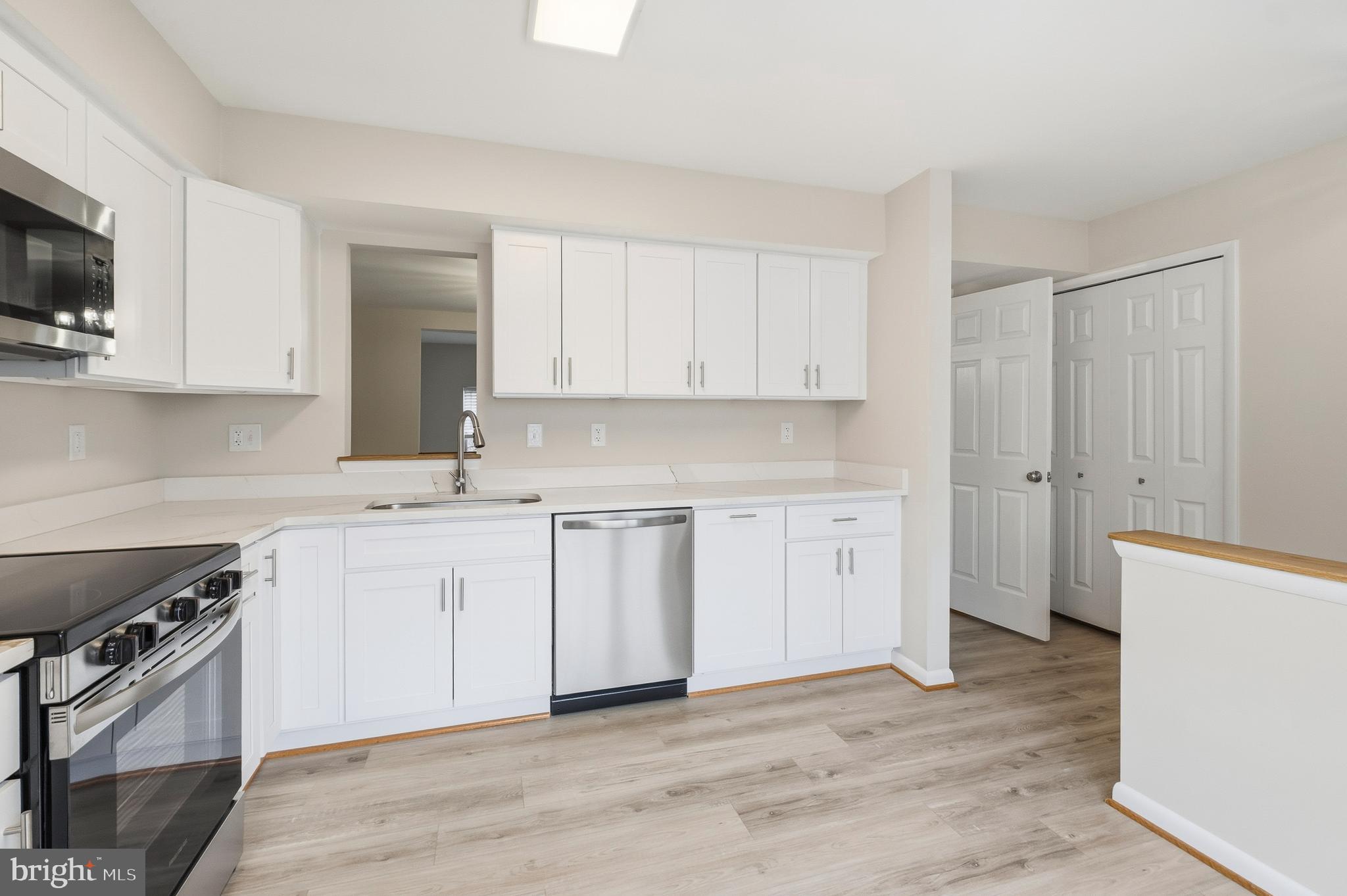 15012 Wheatland Place Laurel, MD 20707 - Photo 3 of 24 a kitchen with stainless steel appliances granite countertop a stove a sink and a microwave