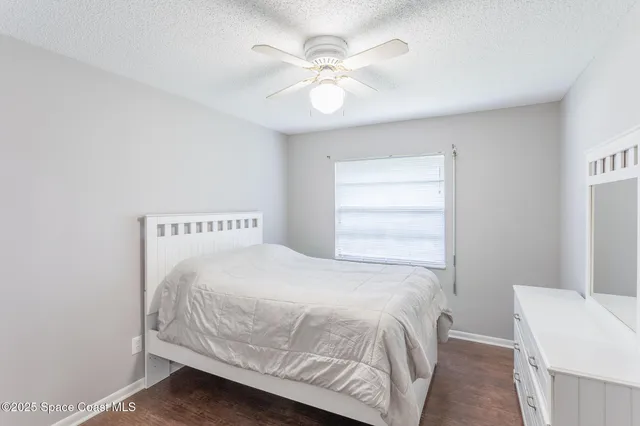 a bedroom with a bed and a ceiling fan