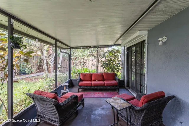 a living room with furniture and a floor to ceiling window