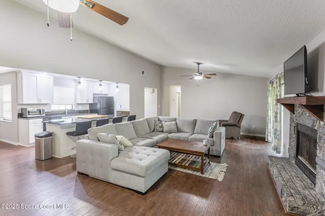 a living room with furniture a fireplace and a flat screen tv