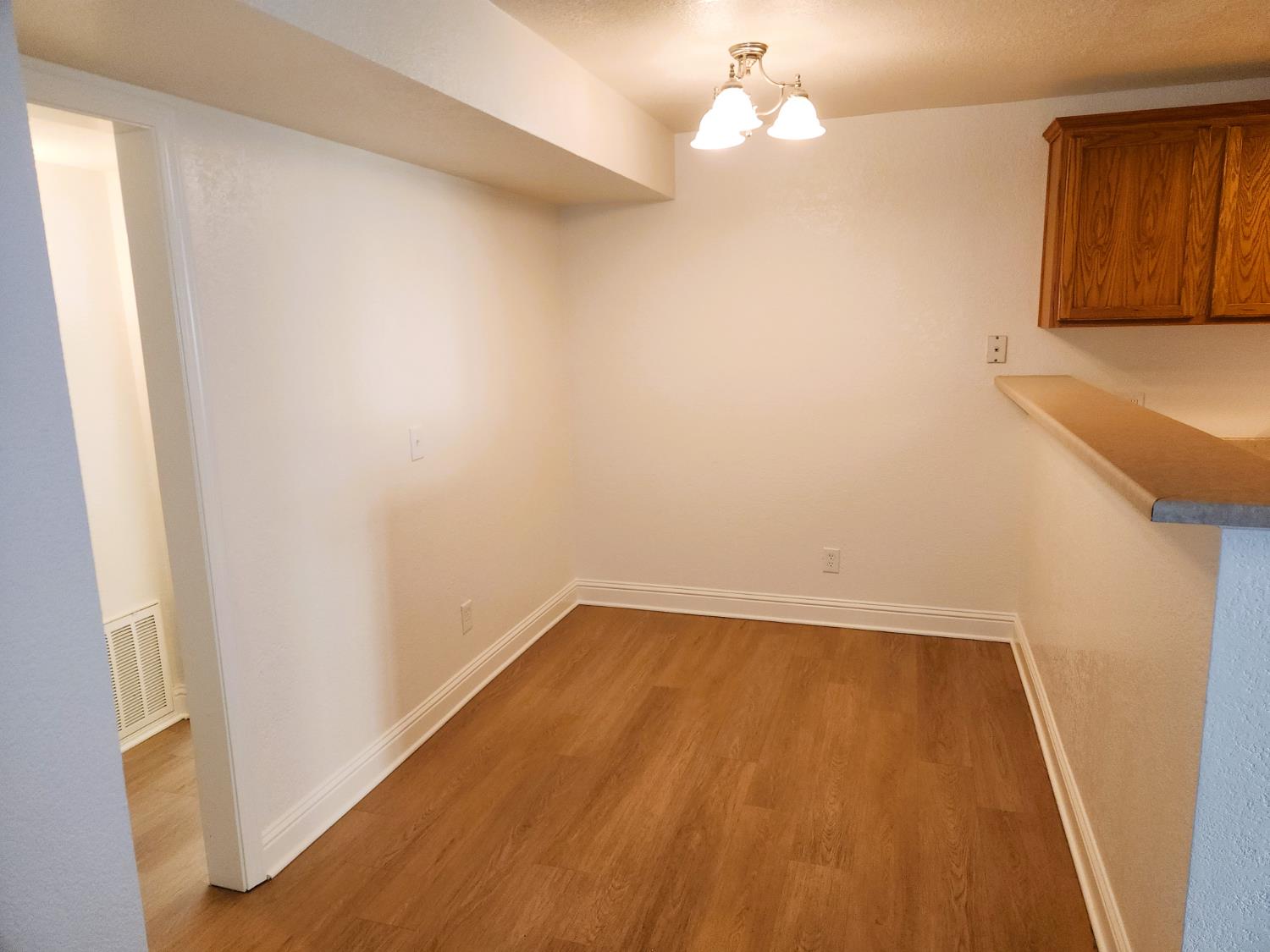 2909 Huntington Boulevard, Unit 105 Fresno, CA 93721 - Photo 5 of 7 a view of an empty room with wooden floor