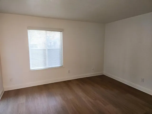 an empty room with wooden floor and a window