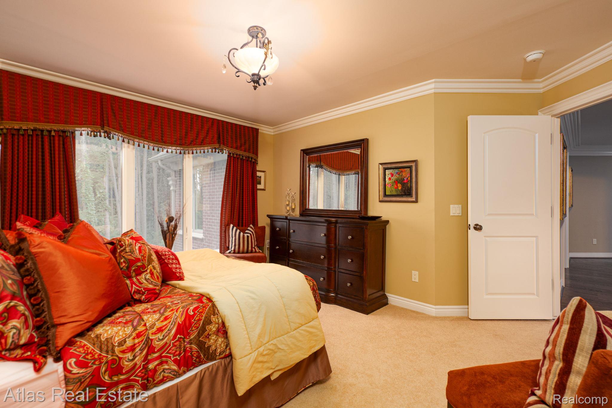 10380 South State Road Goodrich, MI 48438 - Photo 57 of 87 Carpeted room featuring a bay window with drapes, crown molding, a ceiling-mounted light fixture, and a paneled door
