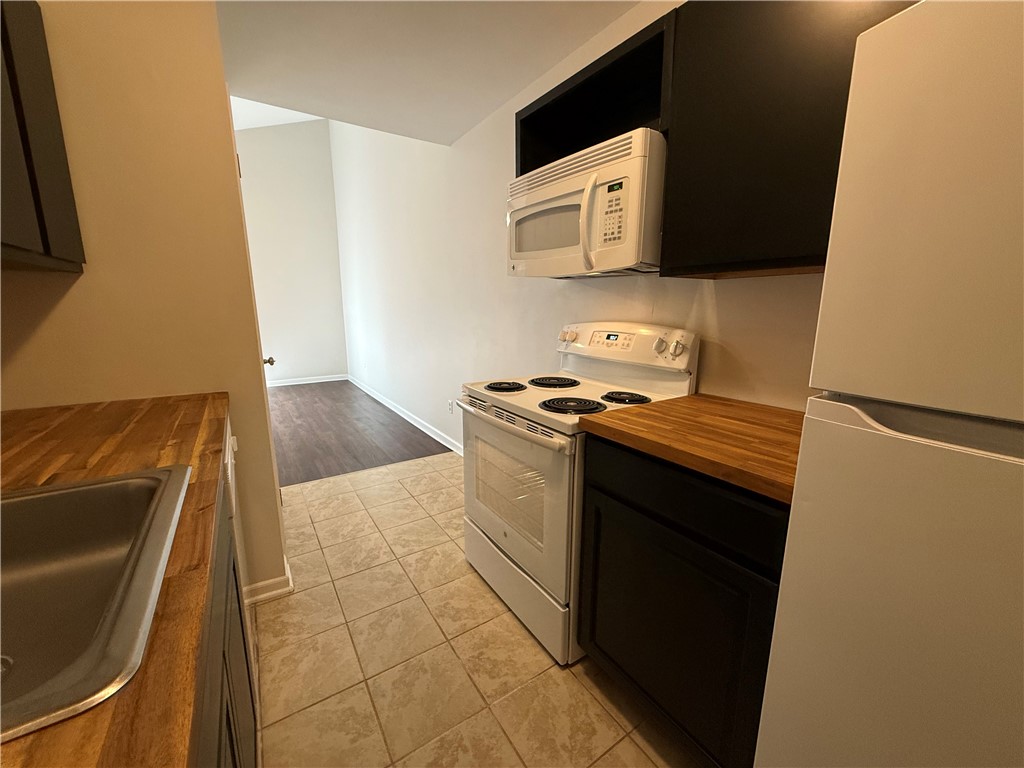 125 Maple Street, Unit 110 Pendleton, SC 29670 - Photo 7 of 18 Cozy and very functional, this kitchen features butcher block countertops and essential appliances for efficient meal preparation.