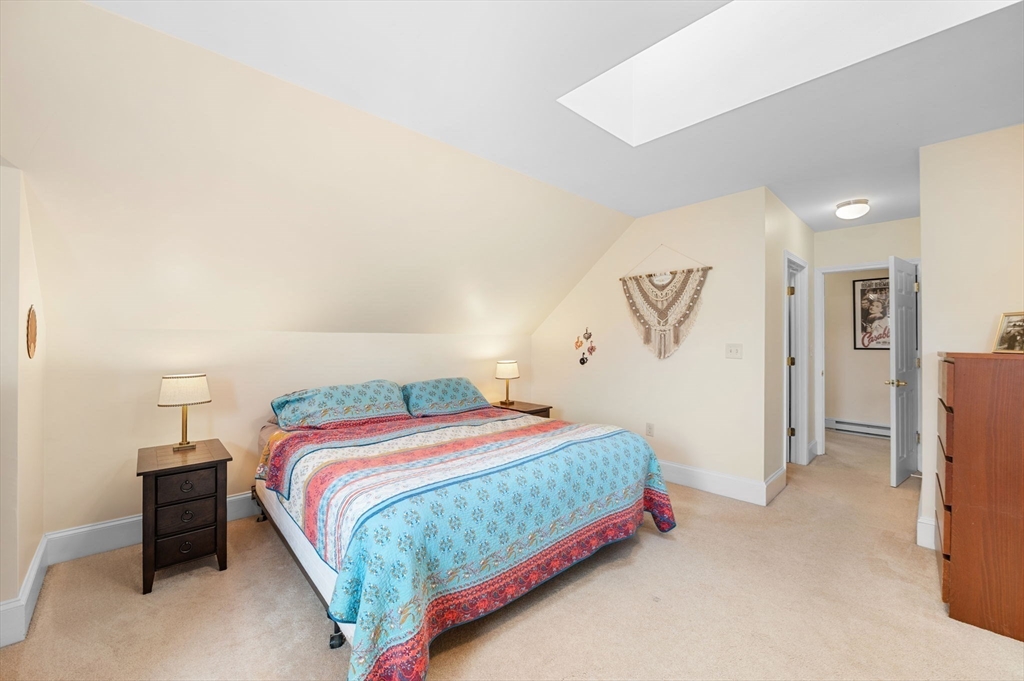 73 Orange Street, Unit 2 Waltham, MA 02453 - Photo 27 of 40 a bedroom with a bed and a cabinets