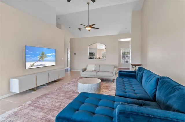 a living room with furniture a ceiling fan and a window