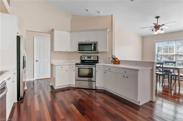 a kitchen with a refrigerator stove and white cabinets