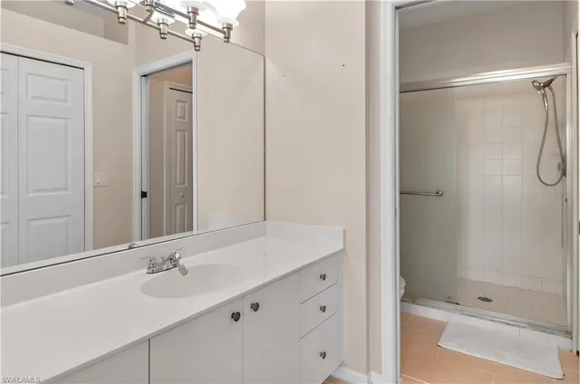 a bathroom with a shower sink vanity and mirror