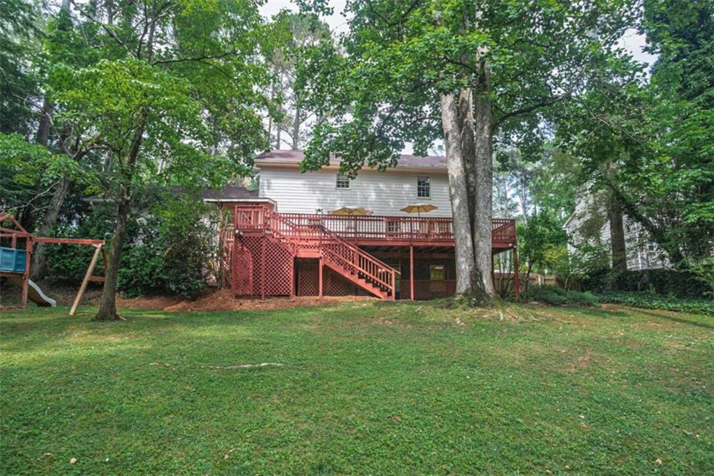 3838 Hunting Ridge Drive Southwest Lilburn, GA 30047 - Photo 54 of 56 a view of a deck with a table and chairs a large tree