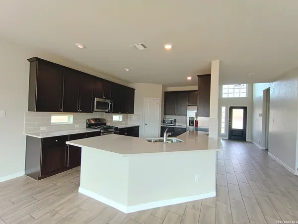 a kitchen with stainless steel appliances a sink a stove top oven a counter space and cabinets