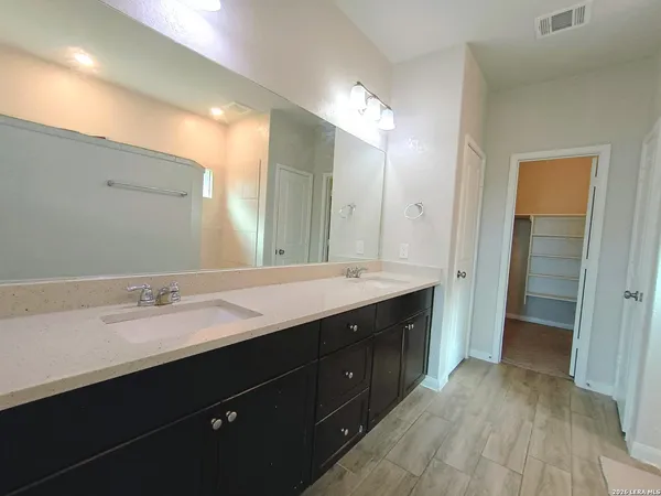 a spacious bathroom with a double vanity sink and a mirror