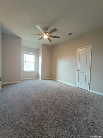 en empty room with windows and fan