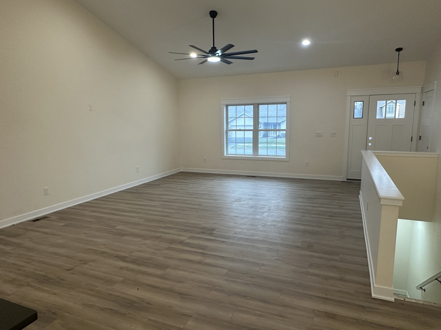 309 Creekside Drive Byron, IL 61010 - Photo 4 of 11 an empty room with wooden floor fan and windows