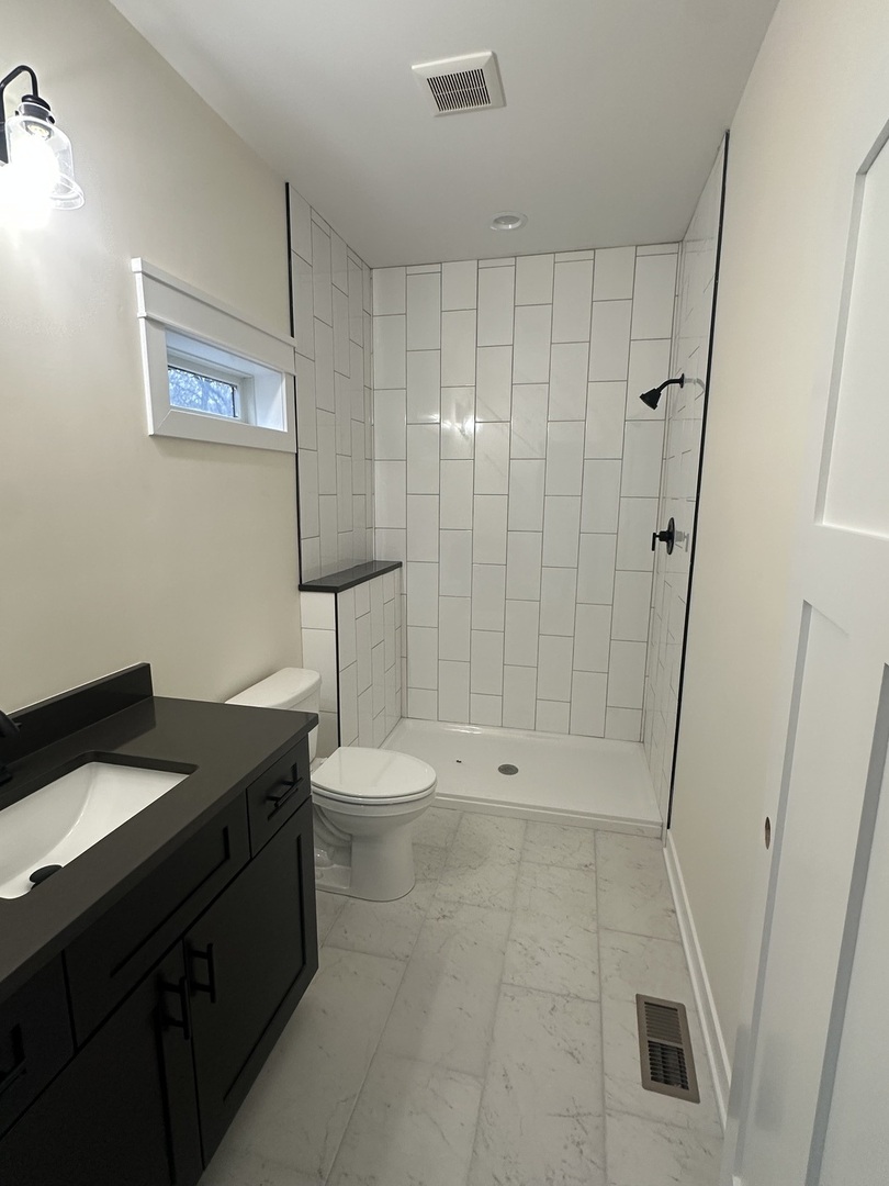 309 Creekside Drive Byron, IL 61010 - Photo 5 of 11 a bathroom with a granite countertop sink a toilet and shower