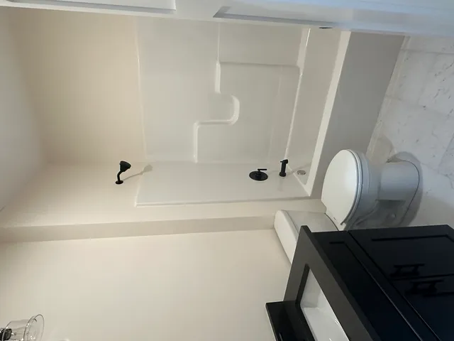 a bathroom with a granite countertop sink a toilet and shower