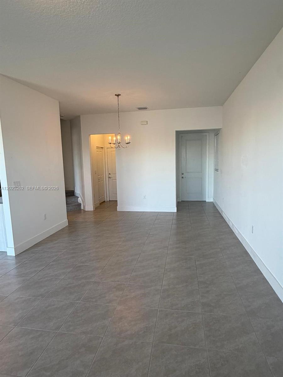 5669 Cerva Lane, Unit 5669 Immokalee, FL 34142 - Photo 29 of 32 an empty room with staircase and white walls