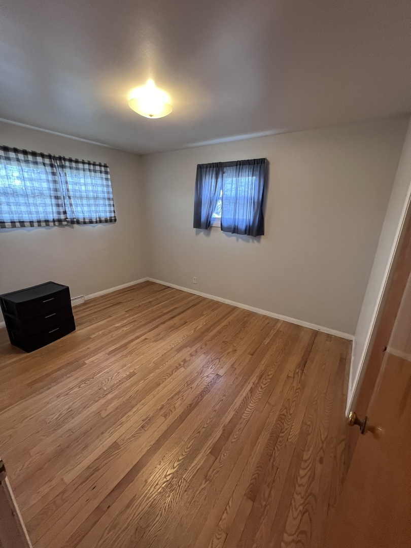 Undisclosed Address Chicago, IL 60656 - Photo 10 of 11 a view of an empty room with wooden floor and a window