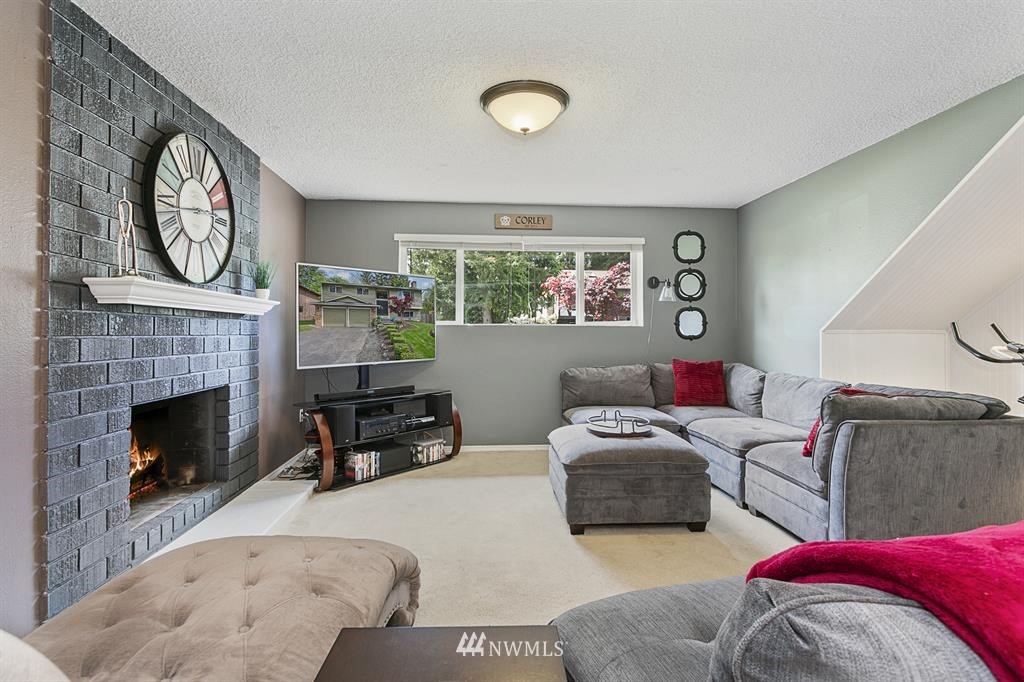 17405 Brook Boulevard Bothell, WA 98012 - Photo 14 of 25 a living room with furniture a clock and a fireplace