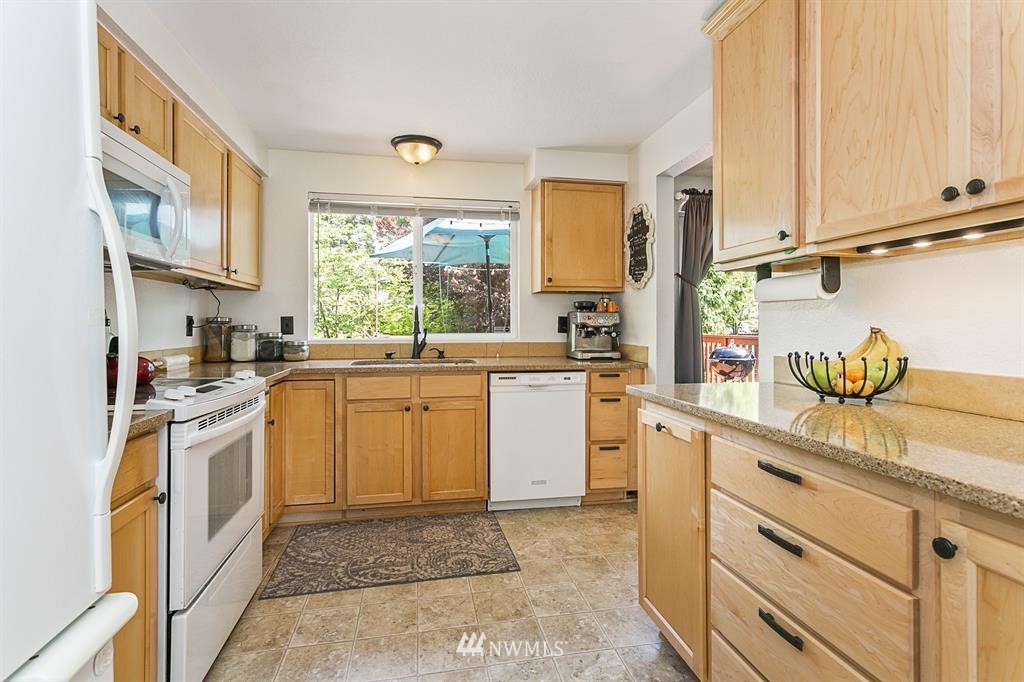 17405 Brook Boulevard Bothell, WA 98012 - Photo 6 of 25 a kitchen with granite countertop white cabinets and white appliances