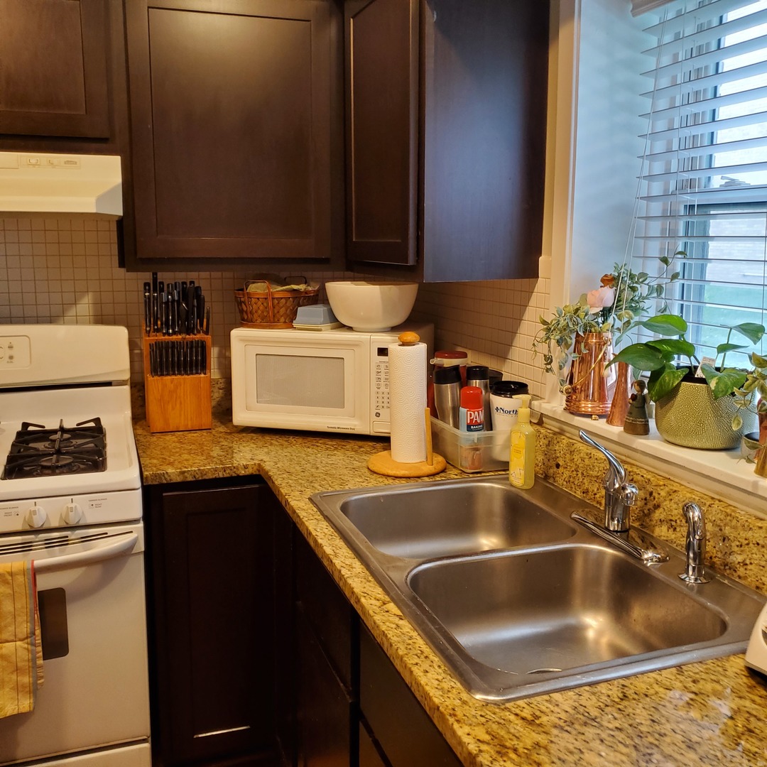 910 Washington Street, Unit 1A Evanston, IL 60202 - Photo 7 of 14 a kitchen with a sink a stove and cabinets