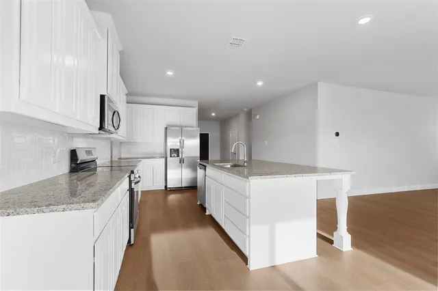 a large kitchen with kitchen island a sink a counter space and stainless steel appliances