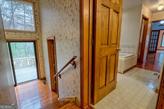 a kitchen with stainless steel appliances granite countertop a refrigerator a sink dishwasher a stove and white cabinets with wooden floor