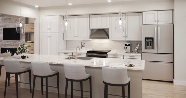 a kitchen with stainless steel appliances a stove a sink a microwave a refrigerator and white cabinets