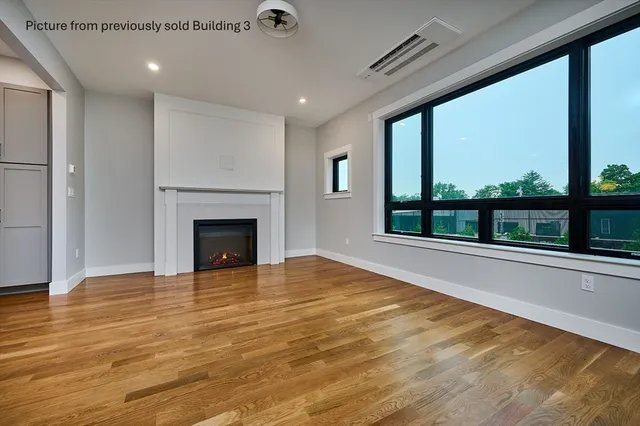 a view of an empty room with a fireplace and a floor to ceiling window