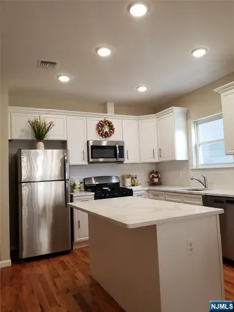 a kitchen with a refrigerator a sink and cabinets