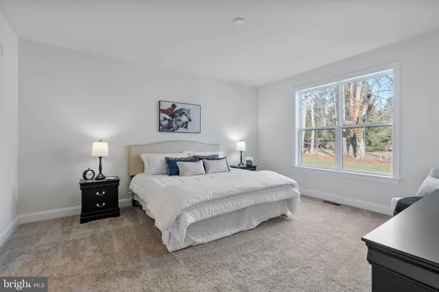 a spacious bedroom with a bed and a window