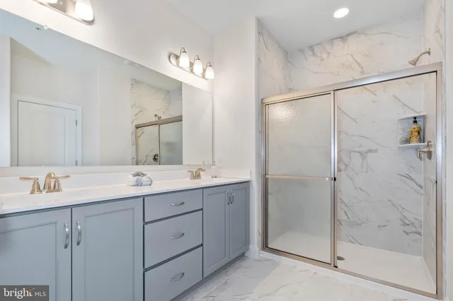 a bathroom with a double vanity sink mirror and shower