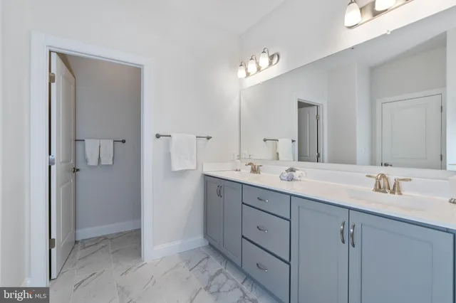 a spacious bathroom with double sink and two mirror
