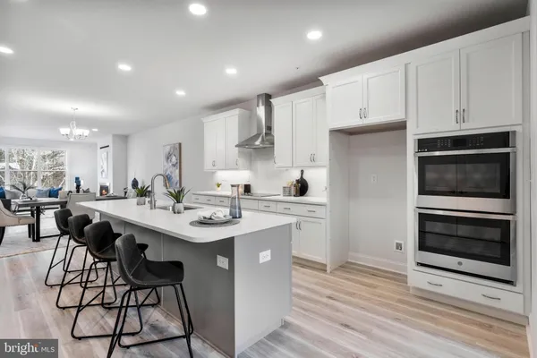 a kitchen with stainless steel appliances kitchen island a white cabinets and couches chair