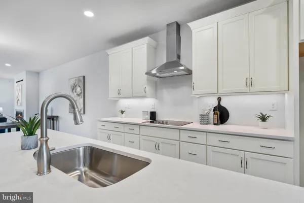 a kitchen with white cabinets a sink and dishwasher