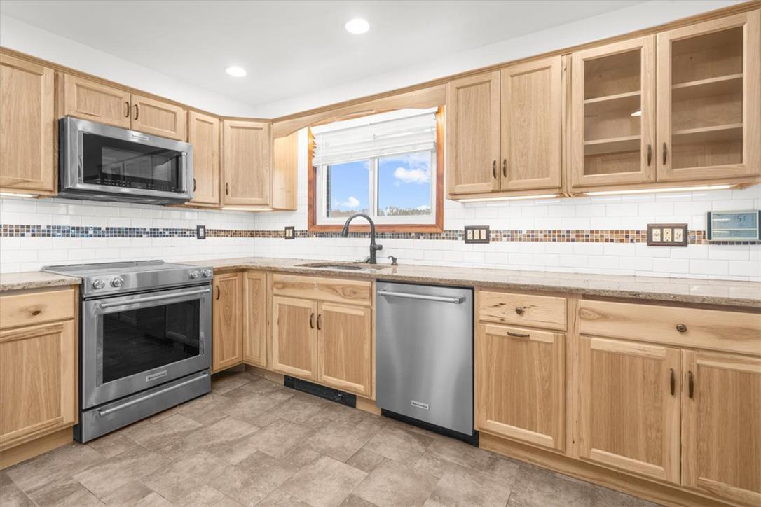 988 Hoch Road Danielsville, PA 18038 - Photo 10 of 29 A well-equipped kitchen features wooden cabinetry, sleek stainless steel appliances, and ample counter space for daily living.