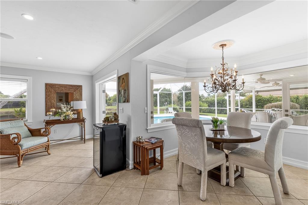1904 Countess Court Naples, FL 34110 - Photo 11 of 33 a dining room with furniture large windows and a chandelier
